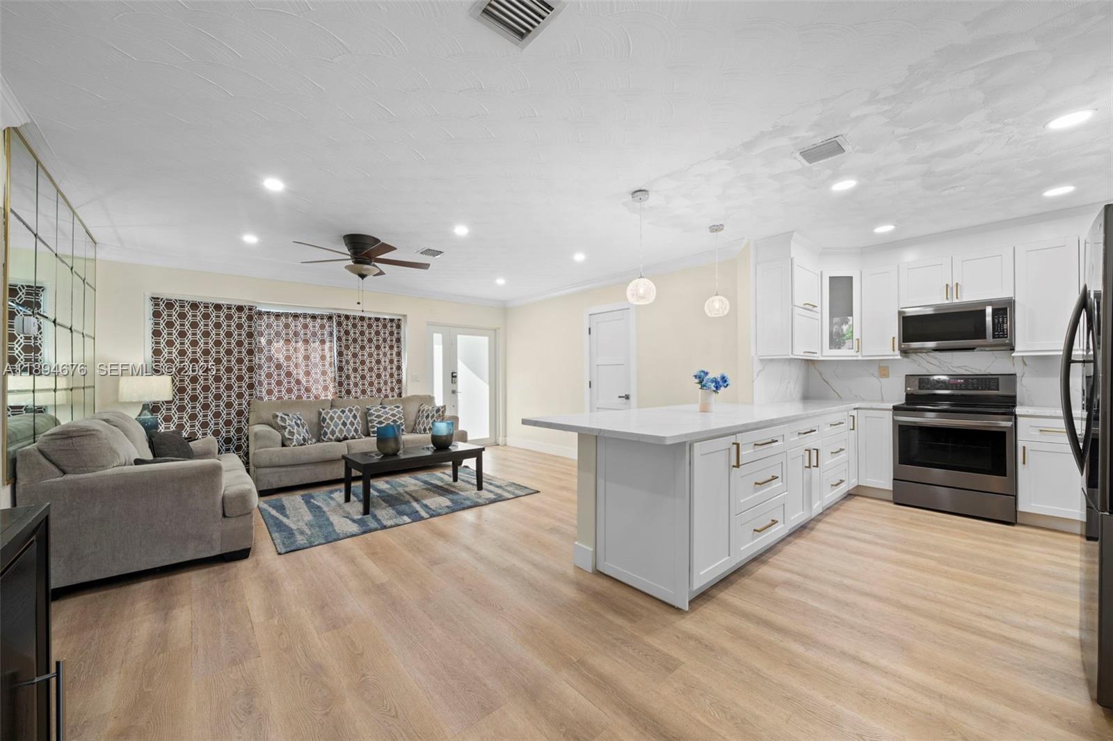 1271 Northwest 87th Street Miami, FL 33147 - Photo 9 of 29 a large white kitchen with a large window a oven a counter space and a sink