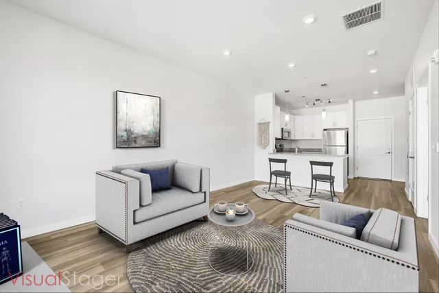 a living room with furniture and a view of kitchen