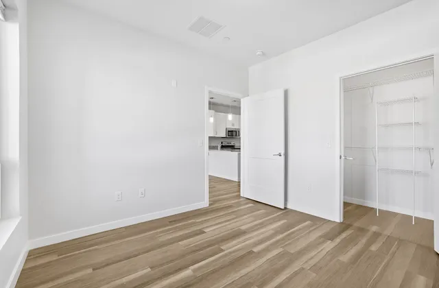 a view of empty room with wooden floor