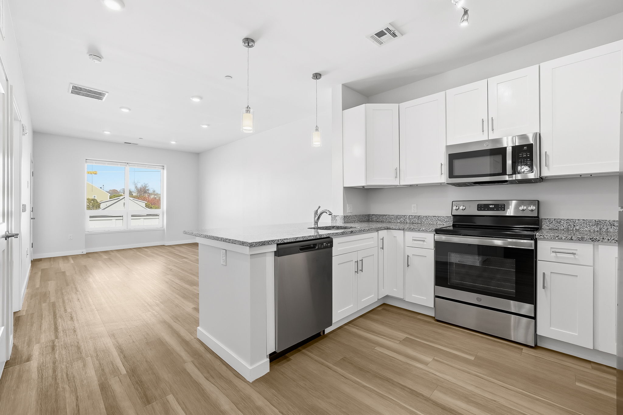 71 Connecticut Avenue, Unit 410 Norwalk, CT 06850 - Photo 10 of 17 a kitchen with stainless steel appliances granite countertop a stove top oven a sink and white cabinets