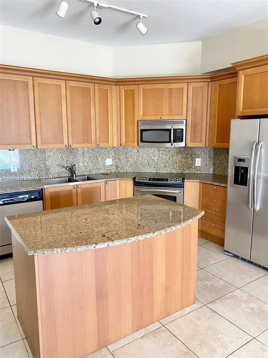 a kitchen with stainless steel appliances granite countertop a sink a microwave counter space and stainless steel appliances