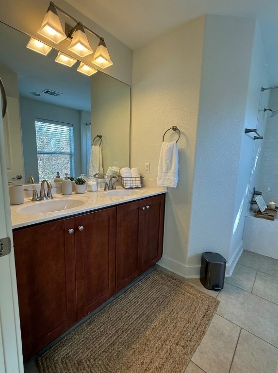 1601 Miriam Avenue, Unit 210 Austin, TX 78702 - Photo 13 of 15 Bathroom featuring double vanity, light tile patterned floors, and shower / washtub combination