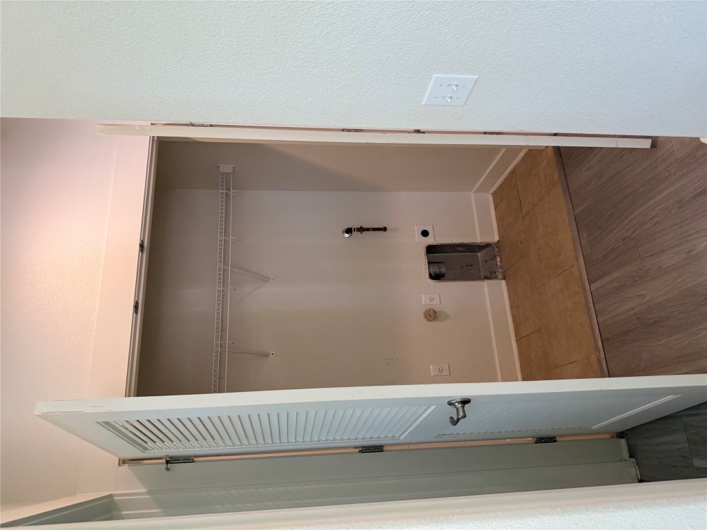 1601 Miriam Avenue, Unit 210 Austin, TX 78702 - Photo 8 of 15 Washroom with dark wood-style floors, a textured wall, gas dryer hookup, and hookup for an electric dryer