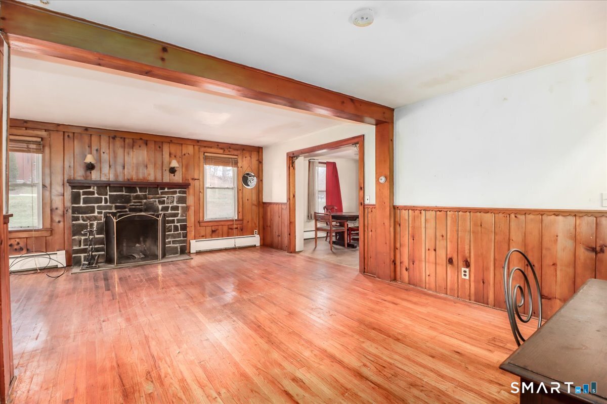 2 Sawmill Road Sherman, CT 06784 - Photo 17 of 40 a view of an empty room with wooden floor and a fireplace