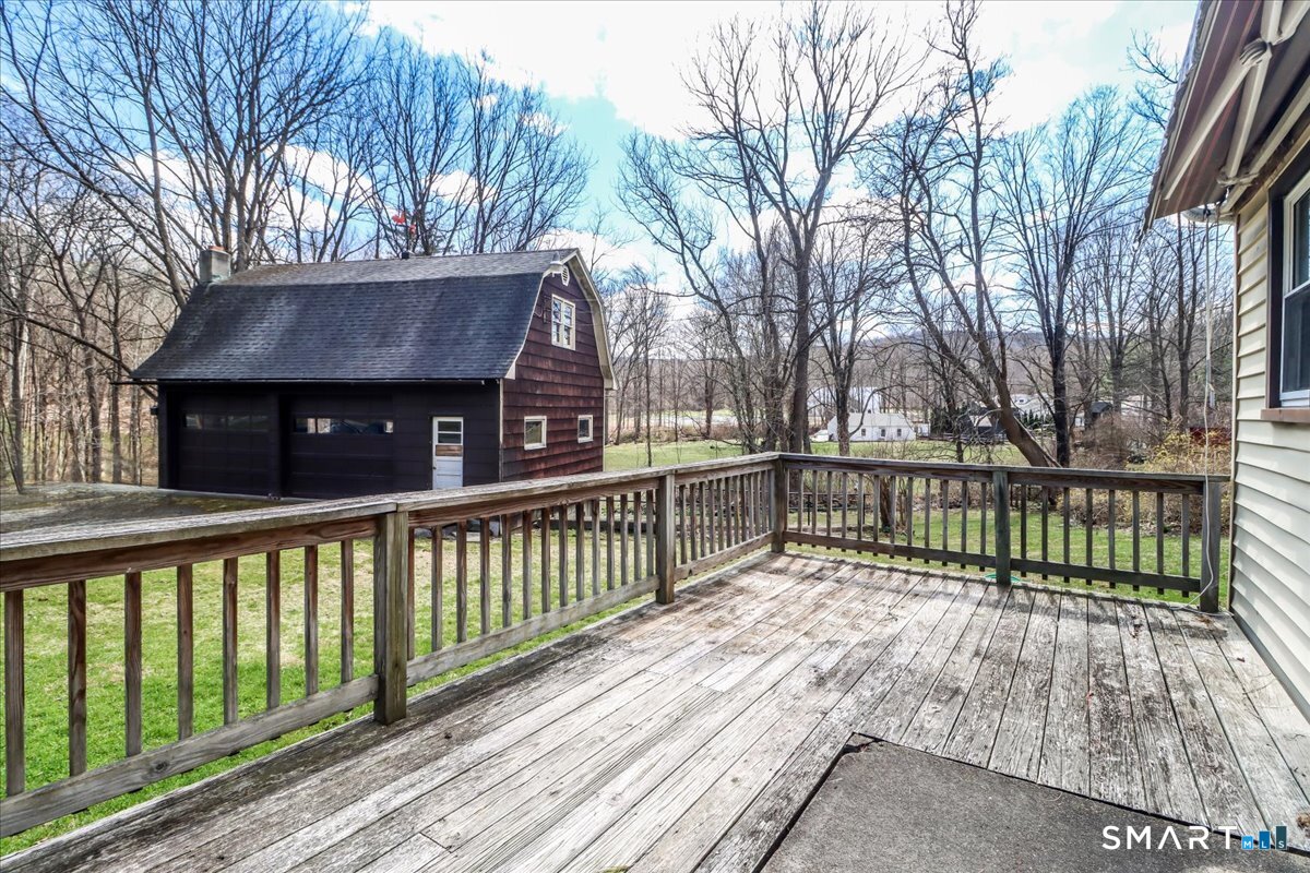 2 Sawmill Road Sherman, CT 06784 - Photo 9 of 40 a view of a house with a wooden deck and a large window