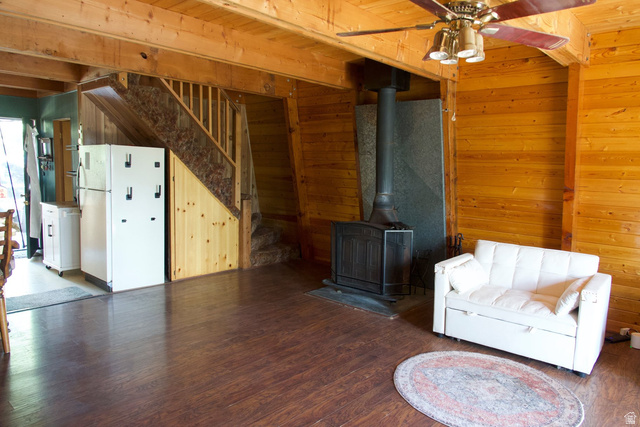 140 East Rim Road Duck Creek Village, UT 84762 - Photo 37 of 45 Unfurnished living room with a wood stove, wooden walls, wood finished floors, and beam ceiling