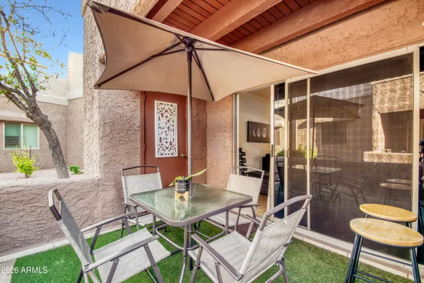 a patio with a table and chairs