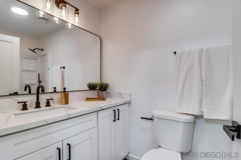 2821 Rosedale Way Spring Valley, CA 91977 - Photo 42 of 70 a bathroom with a sink a toilet a mirror and shower curtain