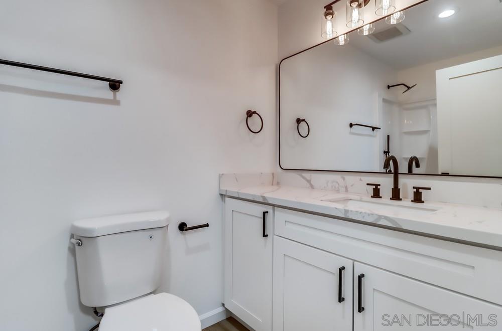 2821 Rosedale Way Spring Valley, CA 91977 - Photo 56 of 70 a bathroom with a granite countertop toilet sink and mirror