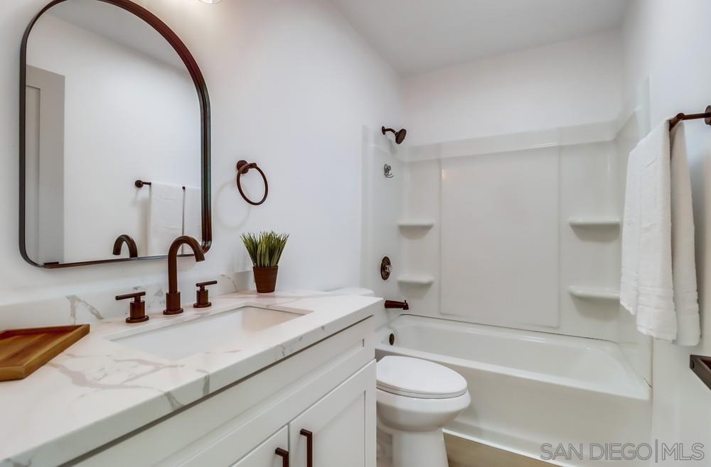 2821 Rosedale Way Spring Valley, CA 91977 - Photo 63 of 70 a bathroom with a granite countertop sink a toilet and a mirror