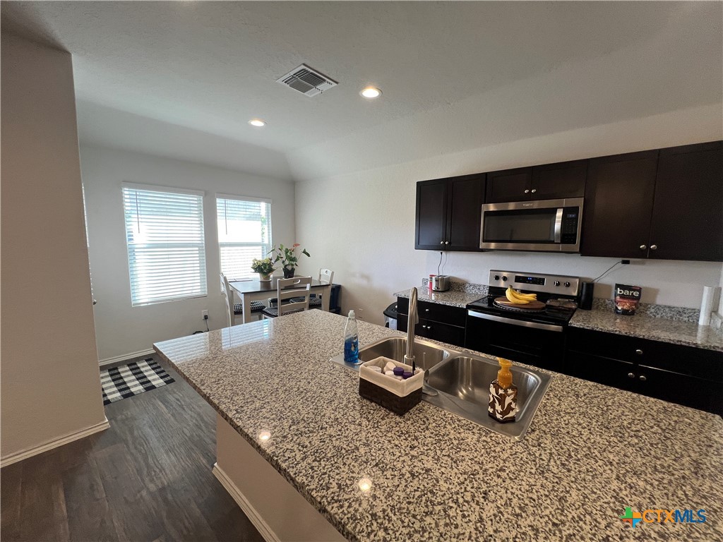 809 Margay Loop Seguin, TX 78155 - Photo 12 of 20 a kitchen with a granite countertop sink stove and refrigerator