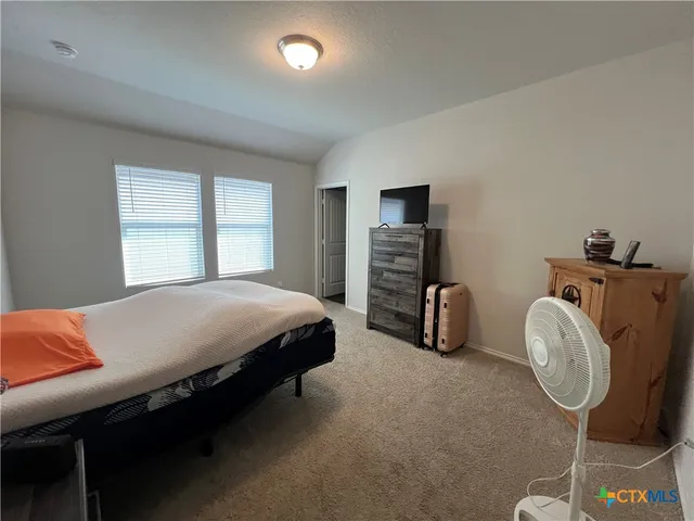 a bedroom with bed and a chandelier