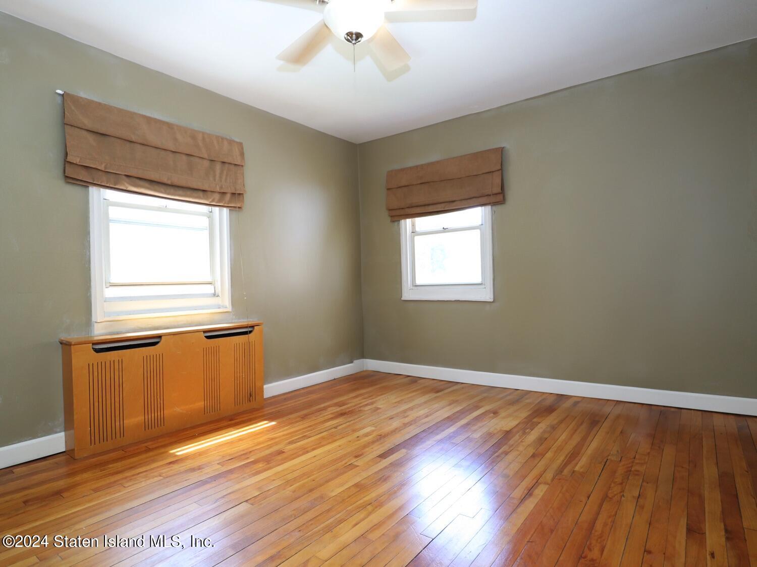 166 Arlo Road, Unit A Staten Island, NY 10301 - Photo 13 of 21 a view of an empty room with wooden floor and a window