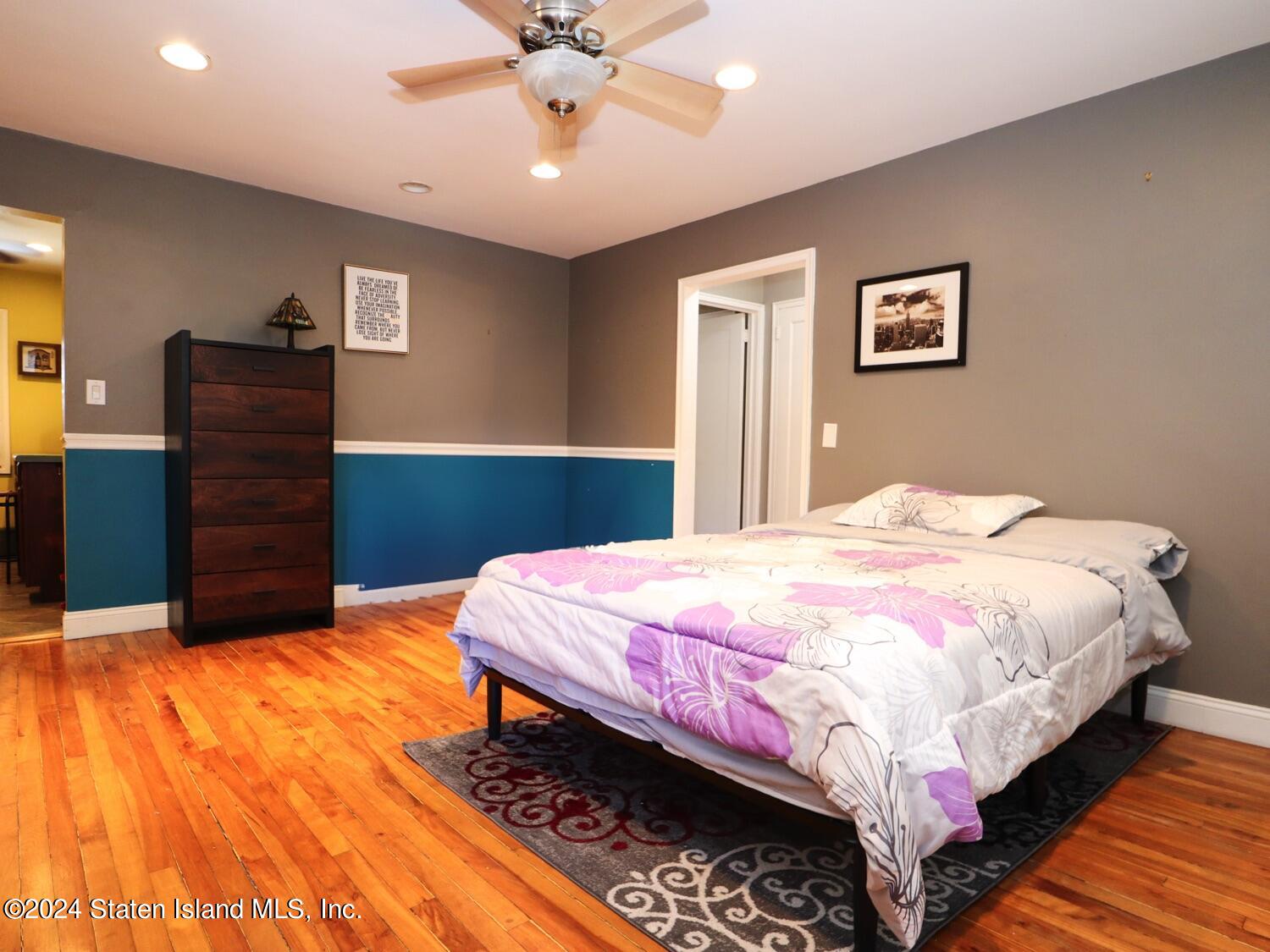 166 Arlo Road, Unit A Staten Island, NY 10301 - Photo 6 of 21 a bedroom with a bed and a chandelier