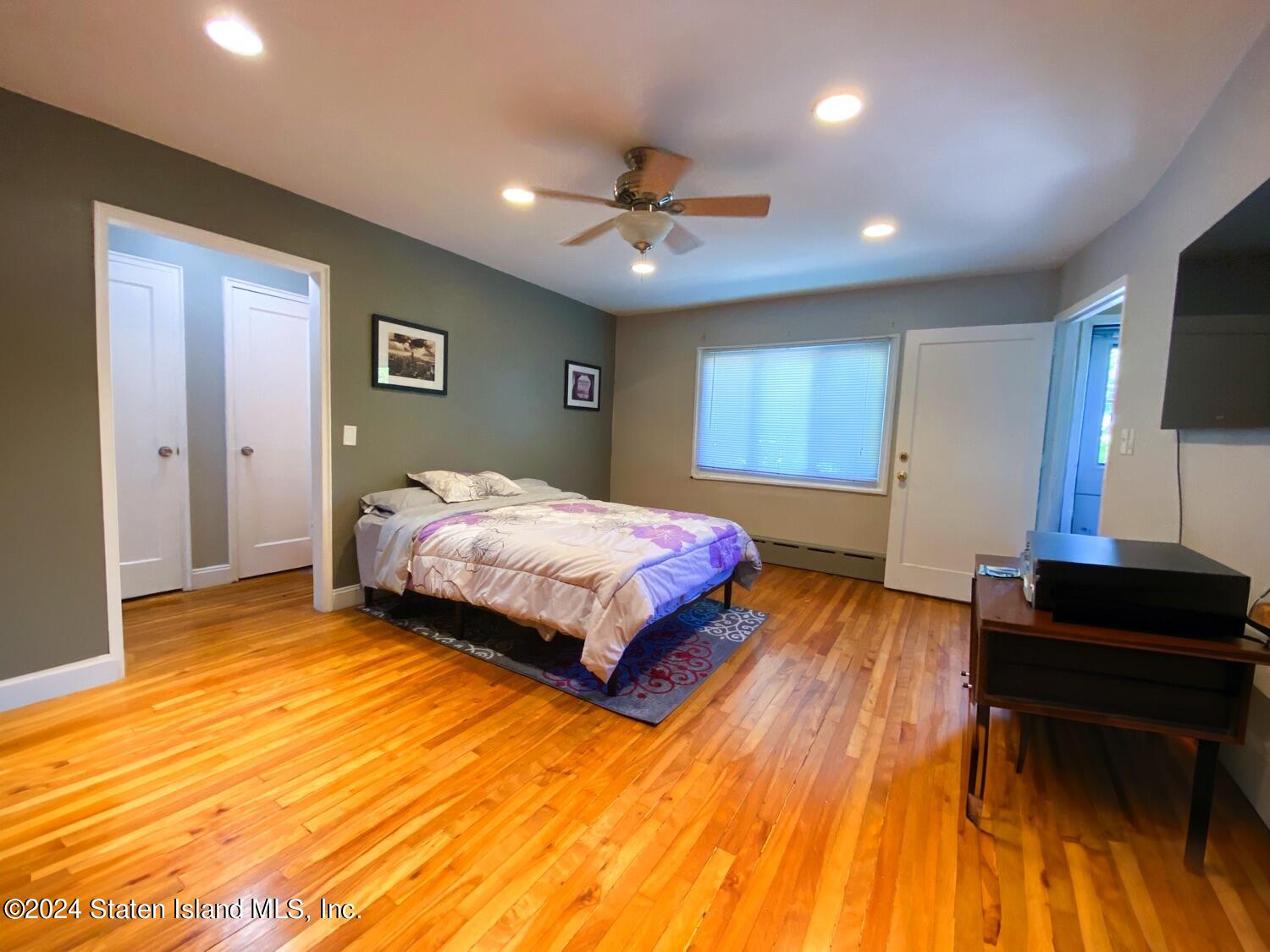 166 Arlo Road, Unit A Staten Island, NY 10301 - Photo 7 of 21 a bedroom with a bed and a chandelier