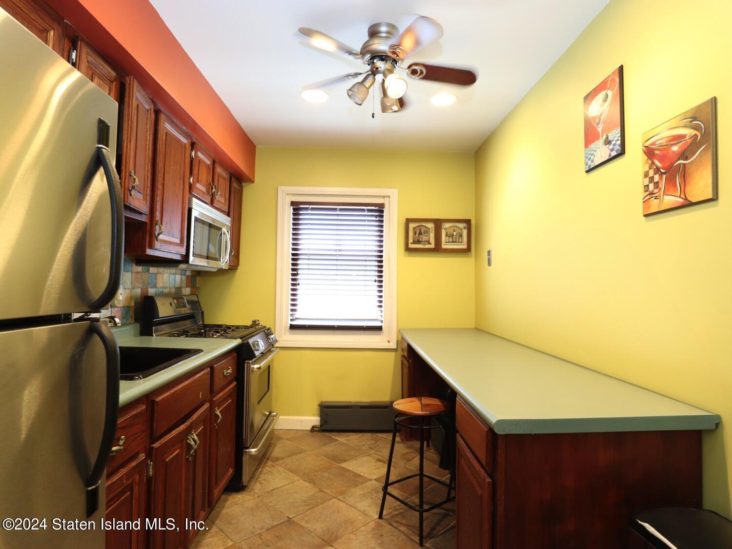 166 Arlo Road, Unit A Staten Island, NY 10301 - Photo 10 of 21 a kitchen with a stove a sink and a refrigerator