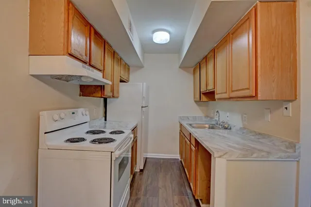a kitchen with a sink a stove and cabinets