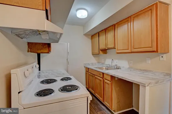 a kitchen with a sink a stove and cabinets