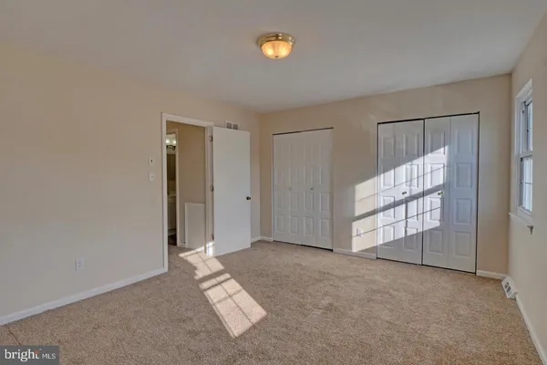 an empty room with windows and closet