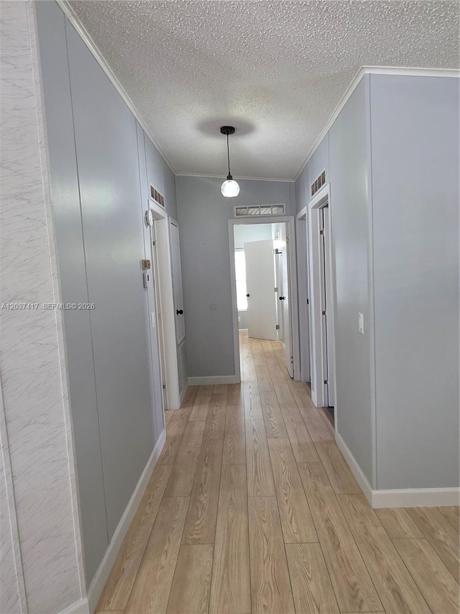 17350 Southwest 232nd Street, Unit 47 Miami, FL 33170 - Photo 3 of 9 a view of a hallway with wooden floor and a chandelier