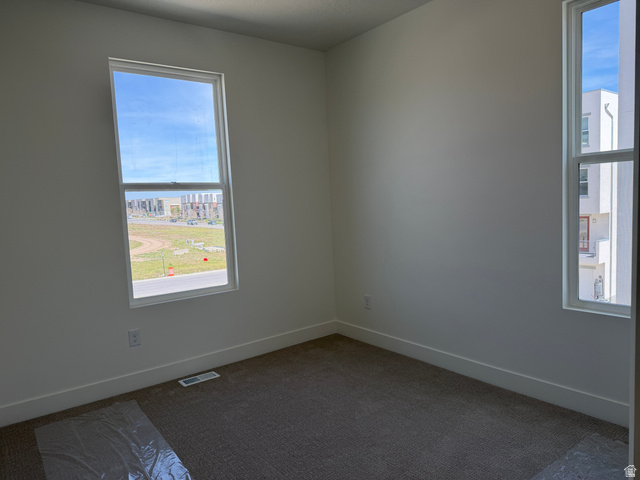 10995 South Freestone Road, Unit 109 South Jordan, UT 84009 - Photo 11 of 20 Empty room with dark colored carpet and baseboards