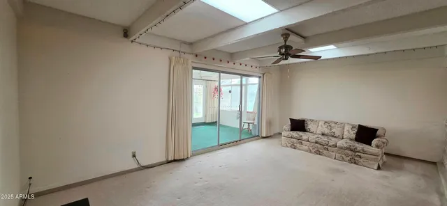 a living room with furniture and a ceiling fan