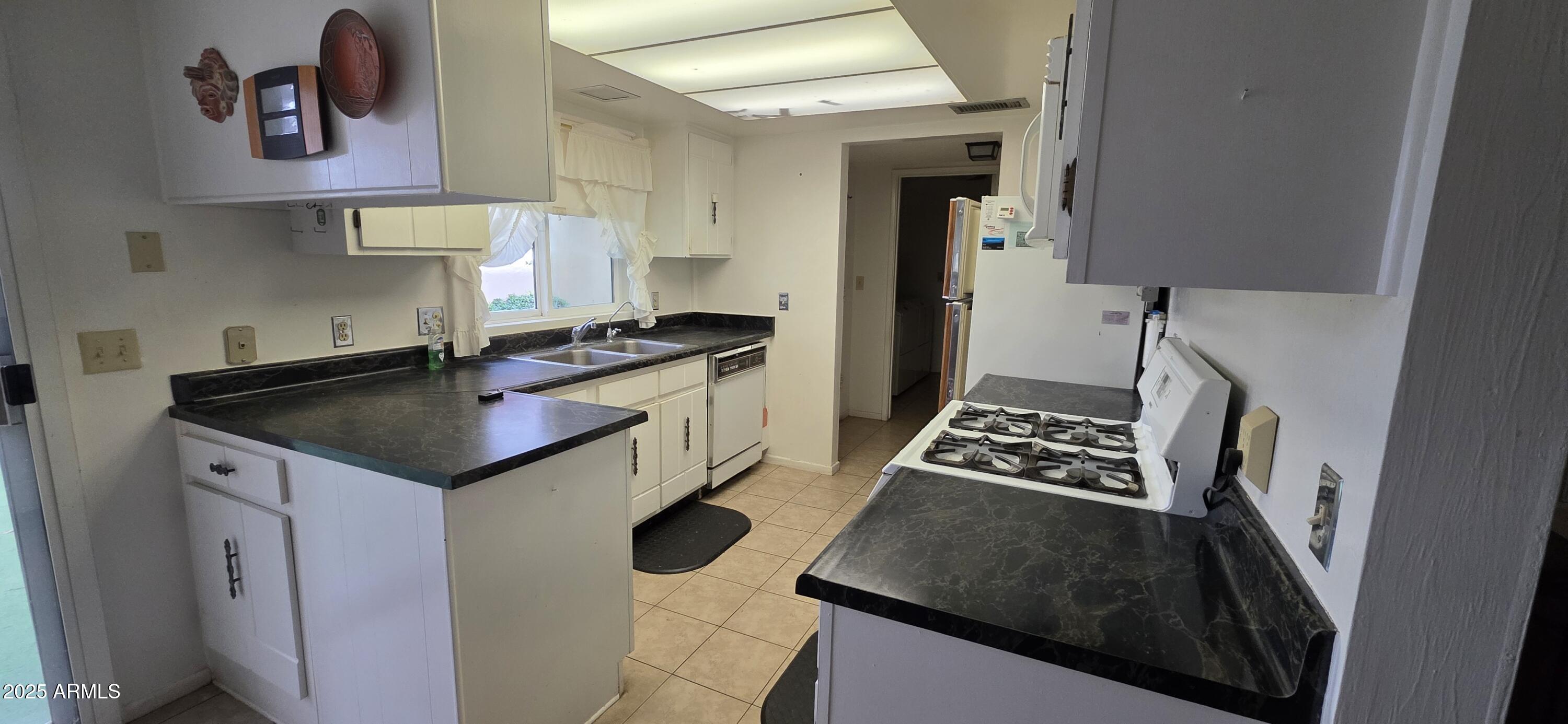 302 North Sage Street Pearce, AZ 85625 - Photo 5 of 38 a kitchen with a sink stove and cabinets
