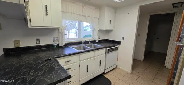 a kitchen with granite countertop white cabinets and sink
