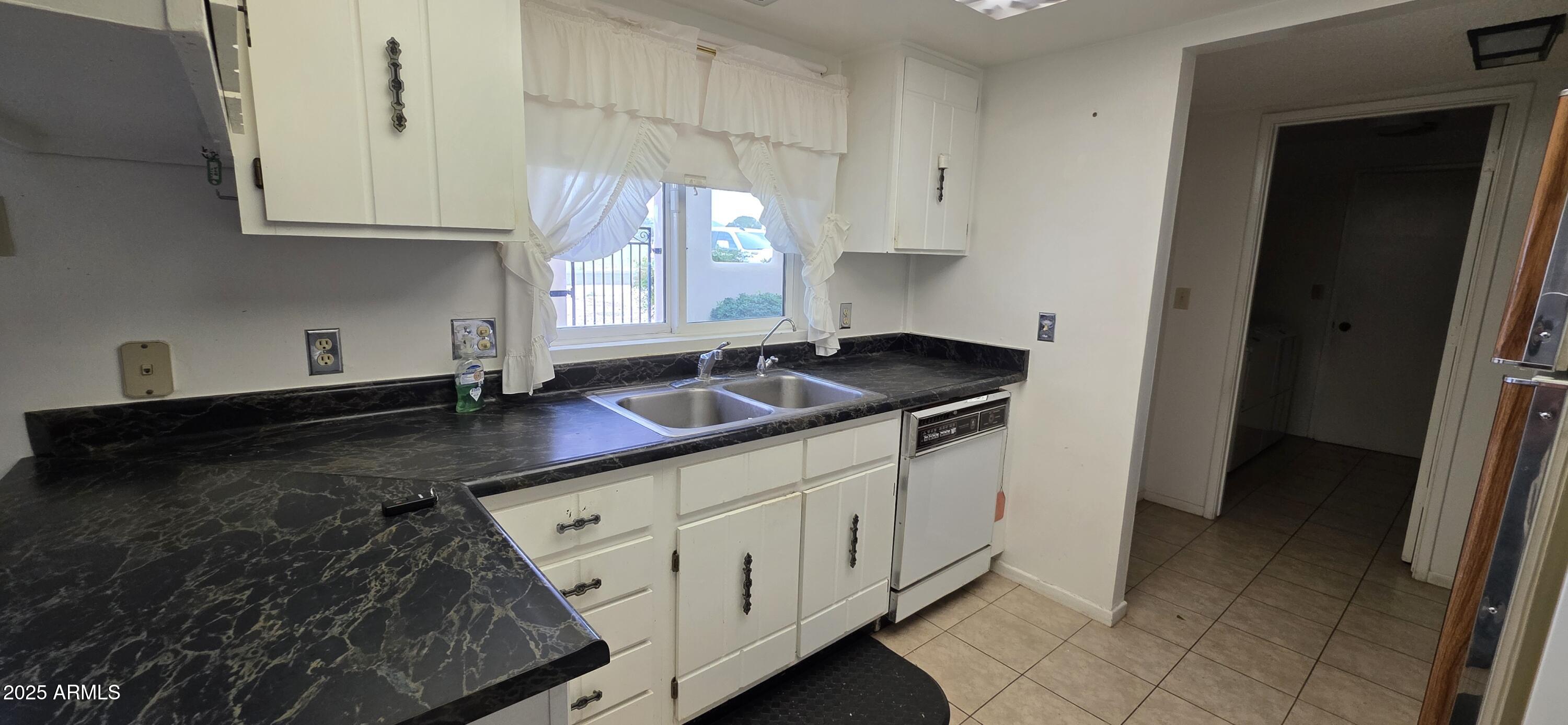 302 North Sage Street Pearce, AZ 85625 - Photo 6 of 38 a kitchen with granite countertop white cabinets and sink