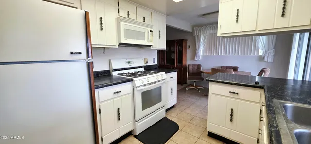 a kitchen with white cabinets and white appliances