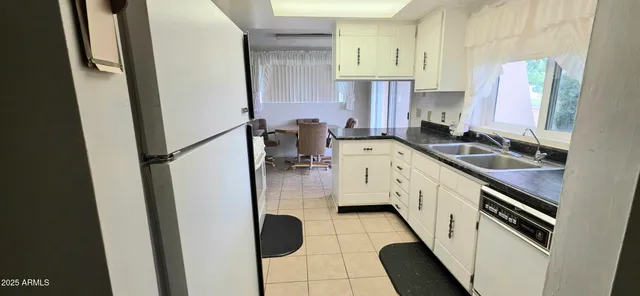 a kitchen with sink refrigerator and cabinets