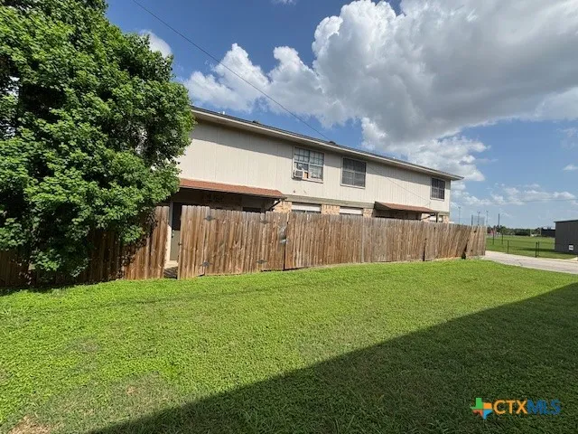 a backyard of a house with lots of green space and outdoor seating
