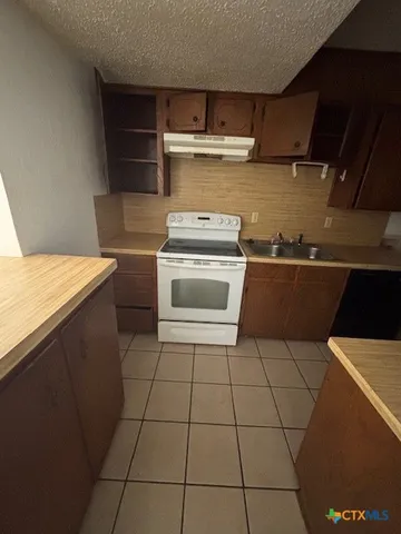 a kitchen with a stove top oven and cabinets
