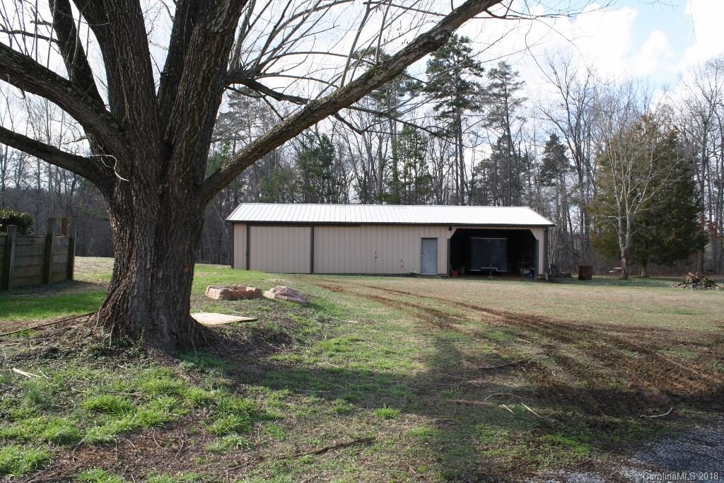 15850 Short Cut Road Gold Hill, NC 28071 - Photo 4 of 18 a front view of a house with a yard and large trees