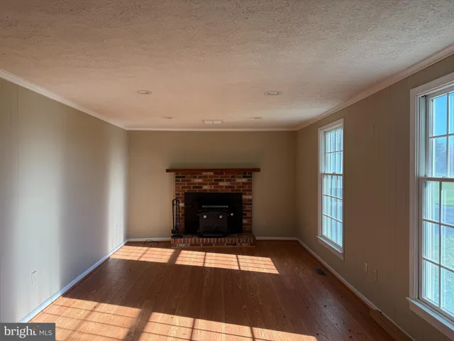 a view of an empty room with window and fire place