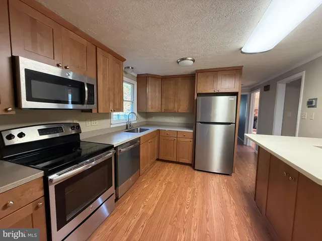 a kitchen with a refrigerator cabinets and wooden floor