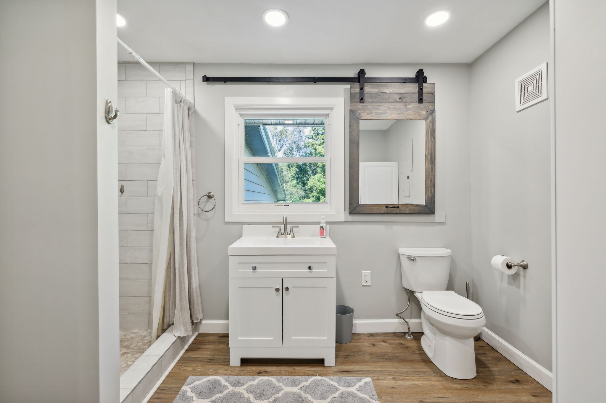 441 Scruggs Hollow Road Rockvale, TN 37153 - Photo 16 of 44 The ensuite primary bathroom boasts a stylish single vanity with a sliding farmhouse mirror, adding a touch of rustic charm! 441 Scruggs Hollow Rd Rockvale, TN 37153