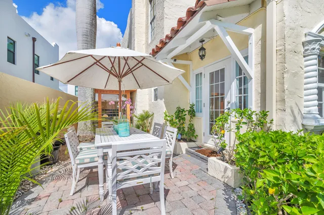a view of a patio with table and chairs under an umbrella