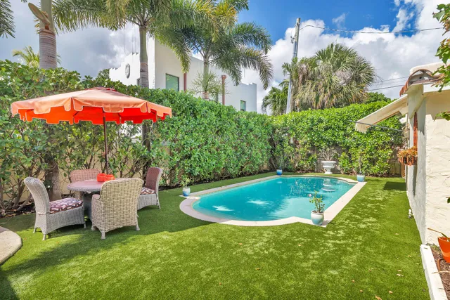 a view of a patio with a table and chairs under an umbrella