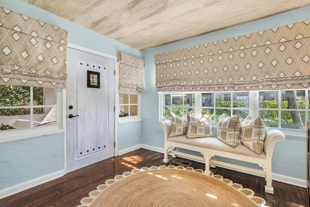 a living room with furniture and large windows