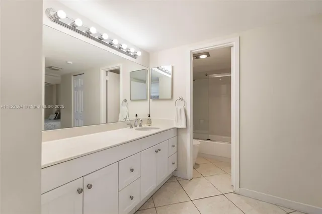 a spacious bathroom with a granite countertop sink a toilet and a mirror