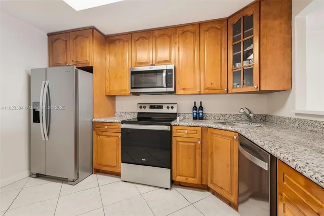 a kitchen with stainless steel appliances granite countertop a refrigerator and a sink