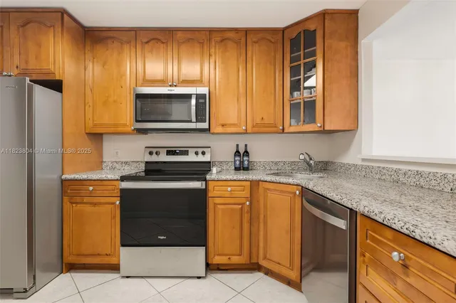a kitchen with stainless steel appliances granite countertop a stove a sink and a microwave
