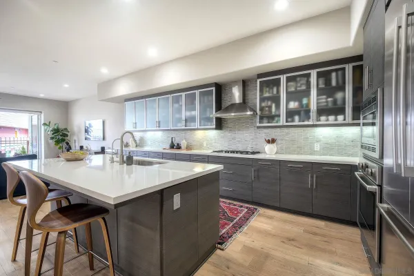 a kitchen with stainless steel appliances granite countertop a sink counter space and a refrigerator