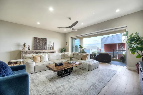 a living room with furniture ceiling fan and a large window