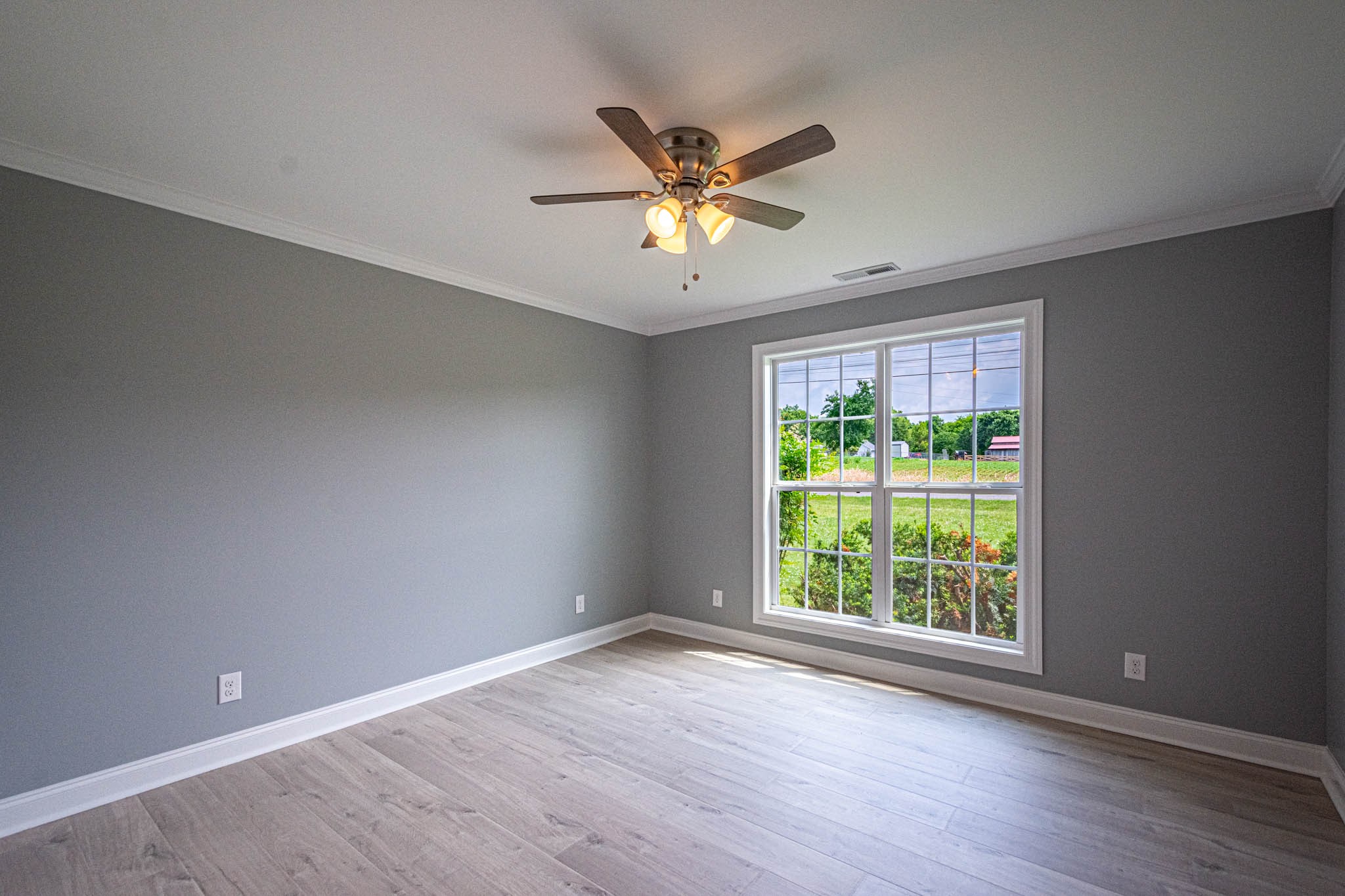 901 Cedar Pl Road Pulaski, TN 38478 - Photo 35 of 59 an empty room with wooden floor ceiling fan and windows