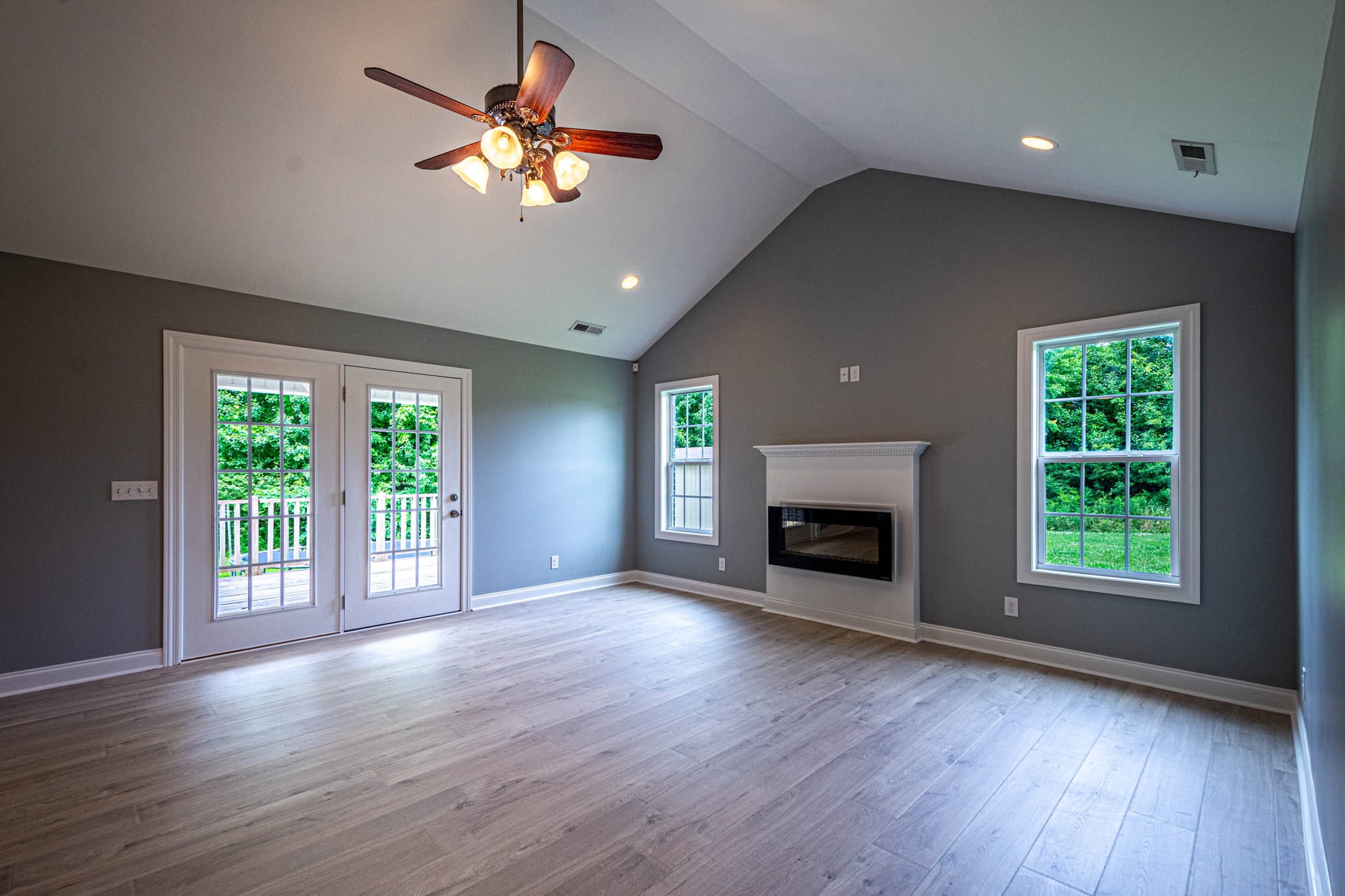 901 Cedar Pl Road Pulaski, TN 38478 - Photo 6 of 59 an empty room with wooden floor a chandelier fan and a fireplace