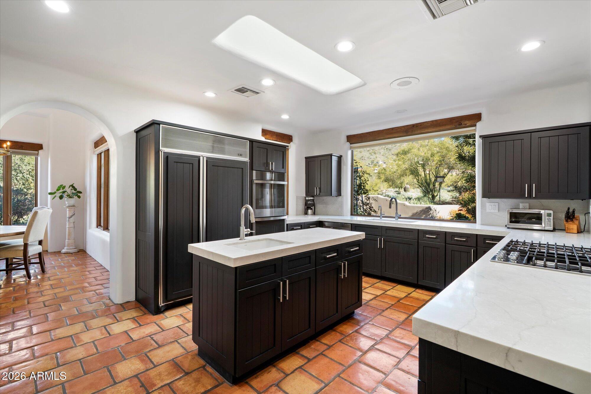 34815 North Arroyo Road Carefree, AZ 85377 - Photo 20 of 60 a kitchen with a stove a sink a refrigerator and a dining table