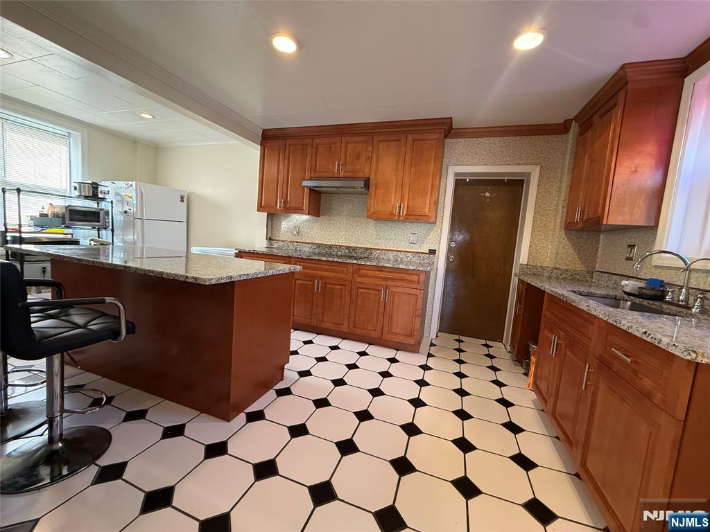88 Main Street Little Ferry, NJ 07643 - Photo 11 of 32 a kitchen with stainless steel appliances a sink a stove a refrigerator a dining table and chair