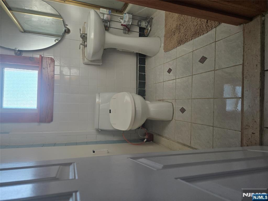 88 Main Street Little Ferry, NJ 07643 - Photo 15 of 32 a bathroom with a sink and mirror
